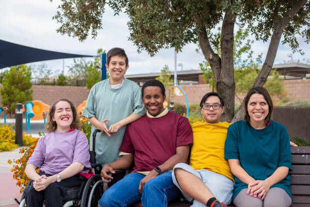 A diverse group of people with Developmental Disabilities sitting together in a park. 